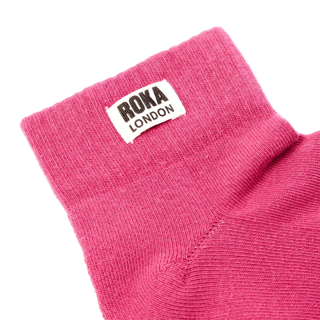 Roka Wembley Cotton Socks in Granita Red, close-up view showing knit fabric and logo label.
