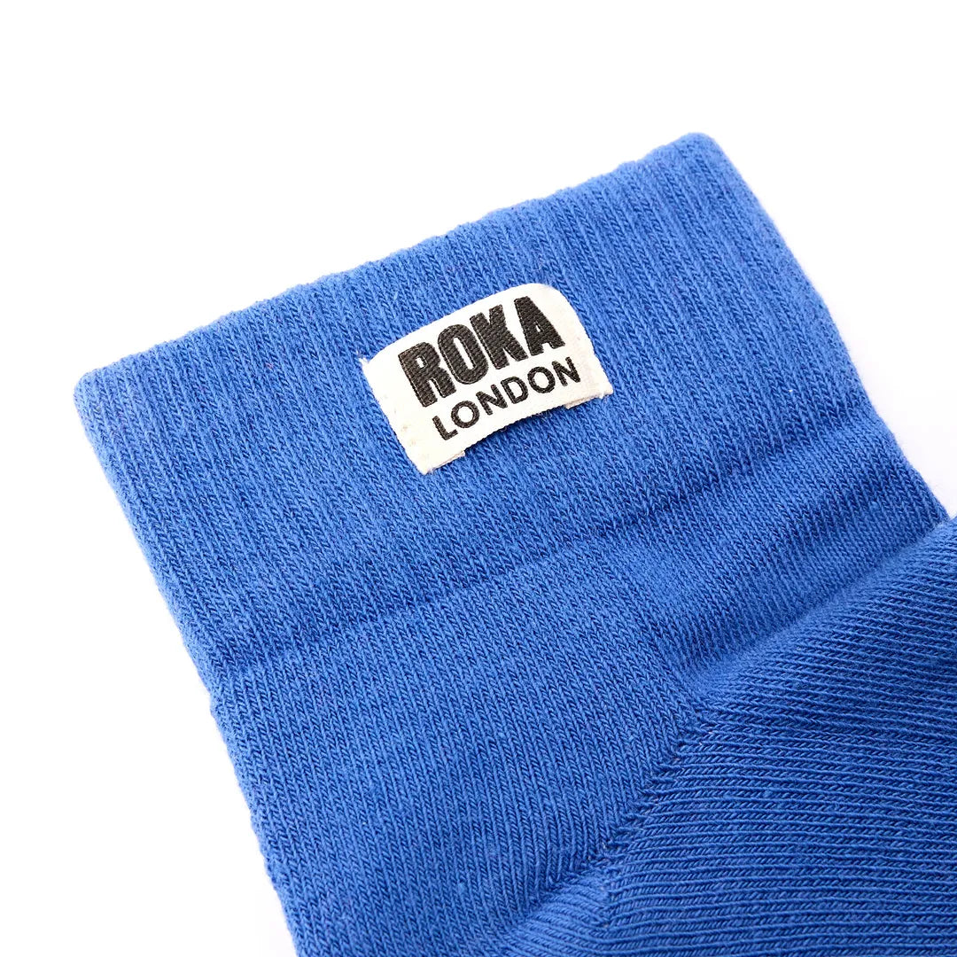 Roka Wembley Cotton Socks in Malibu Blue, showing close-up of fabric and label with 