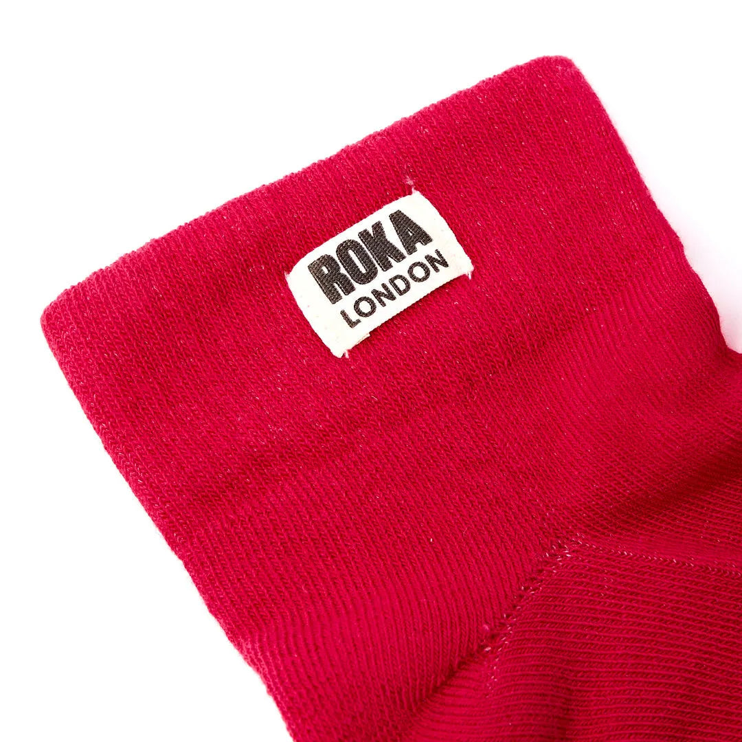 Red Roka London cotton sock with logo patch, stylish scarlet design, soft breathable material, perfect for casual wear.