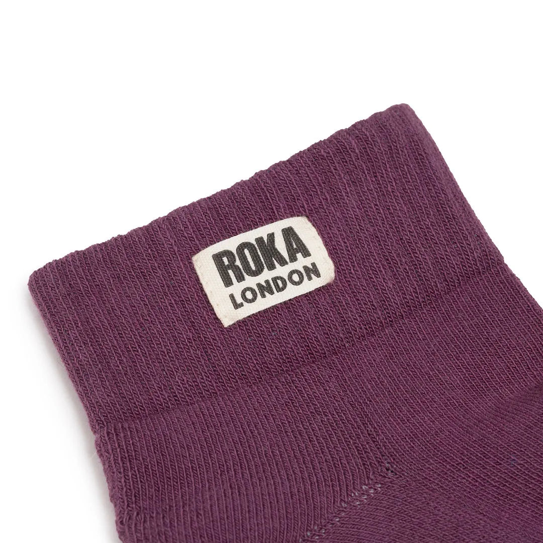 Roka Wembley Ladies Cotton Socks in Berry, featuring a close-up of the purple ankle sock with ROKA London label.