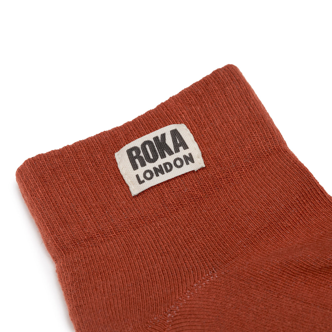 Roka London women's cotton ankle socks in rust color with black logo label, breathable and comfortable for everyday wear.