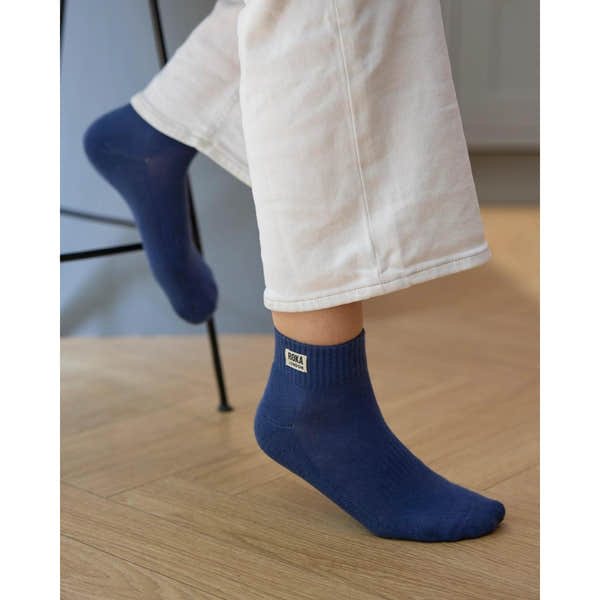 Roka Wembley men's coastal blue organic cotton sock, one size, worn with beige pants, close-up of sock label and texture.