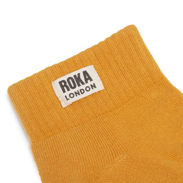 Yellow organic cotton sock with Roka London branding, one size, soft and comfortable men's footwear accessory.