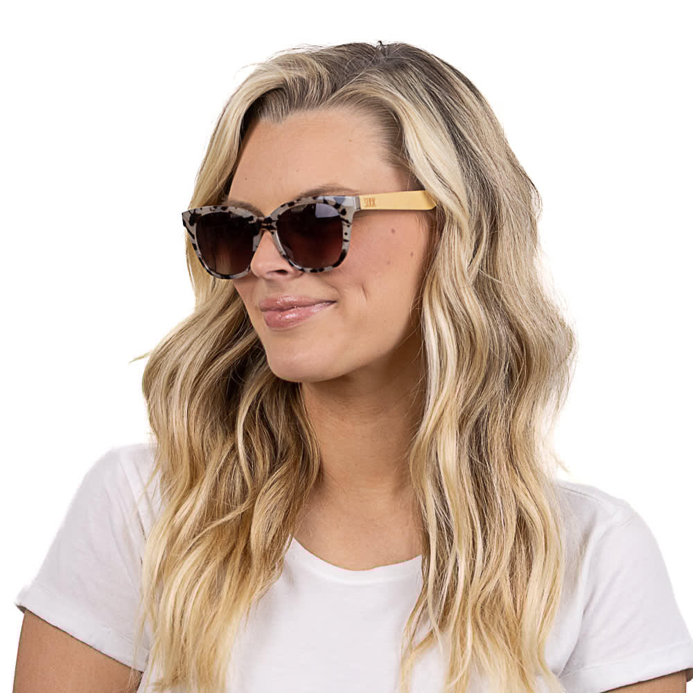 SOEK Lila Grace Ivory Tortoise Magnifying Blue Light Reader sunglasses on woman with wavy blonde hair, white t-shirt, and tortoise frame.