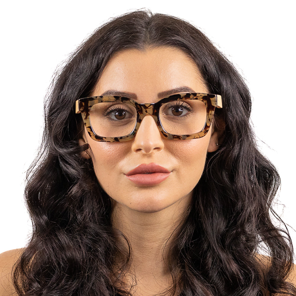 Woman wearing Soek Zahra Opal Tortoise Blue Light Reader glasses with magnifying lenses and tortoise shell frame.