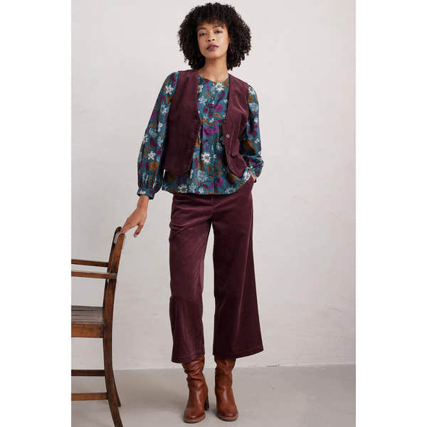 Seasalt Thornapple shirt in woodblock bloom print with dusky jade color, paired with burgundy corduroy pants and brown boots.