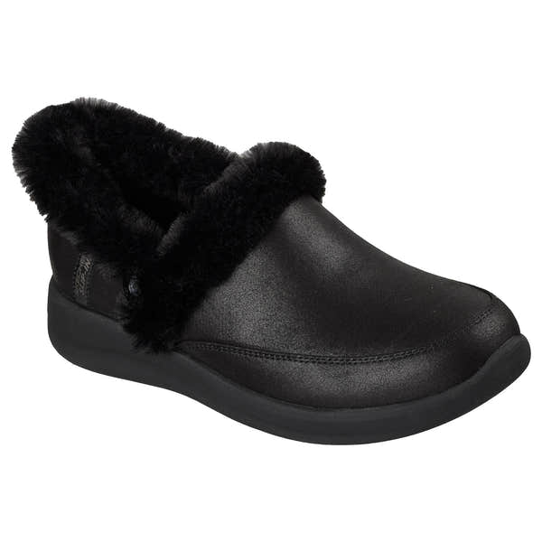 Skechers Cozy Escape slip-on women's black vegan leather slippers with water-resistant exterior and plush faux fur lining.
