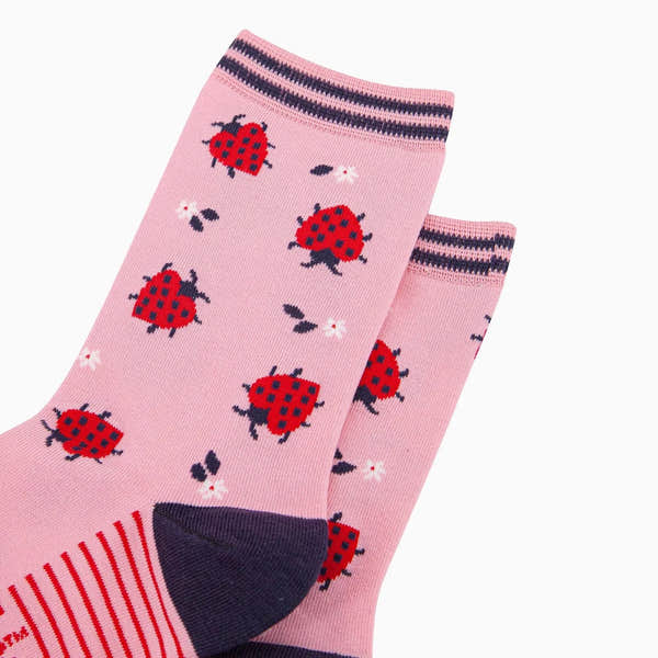 Pink bamboo socks with red ladybird and floral pattern, ribbed top, striped detail, and navy toe for women.