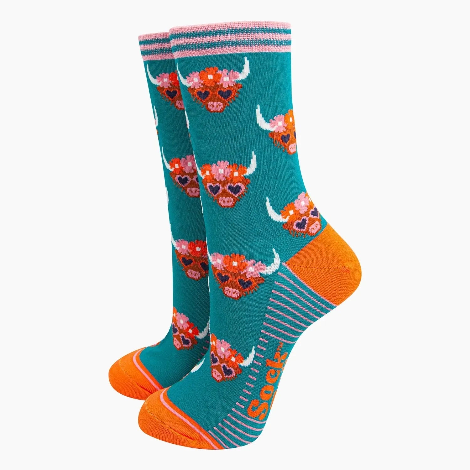 Sock Talk teal bamboo socks featuring Highland cow with floral crown, orange toe, and pink-striped cuff detail.