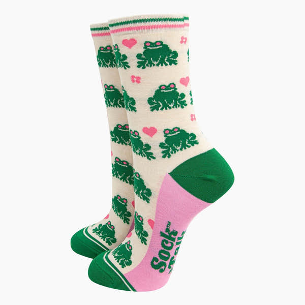 Ladies cream bamboo socks with green frogs, pink hearts, and "Sock Talk" text, featuring green accents on toes and cuffs.