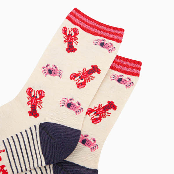 Ladies cream bamboo socks with lobster and crab designs, red and pink striped cuffs, navy toe, and heel.