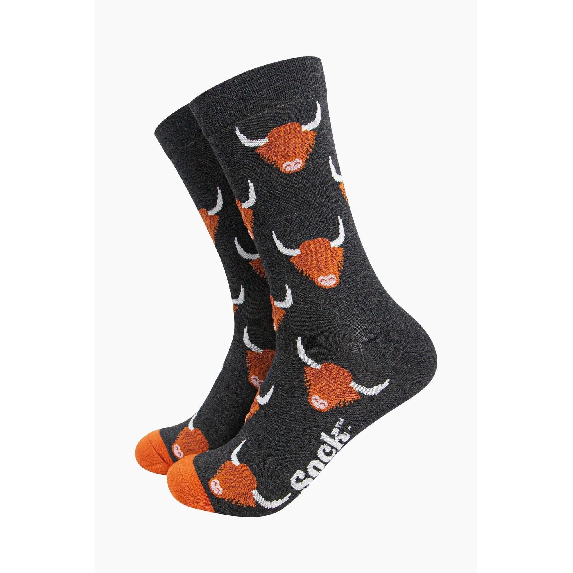 Men's black bamboo socks with Highland cow pattern, featuring orange toes and white detail, by Sock Talk.
