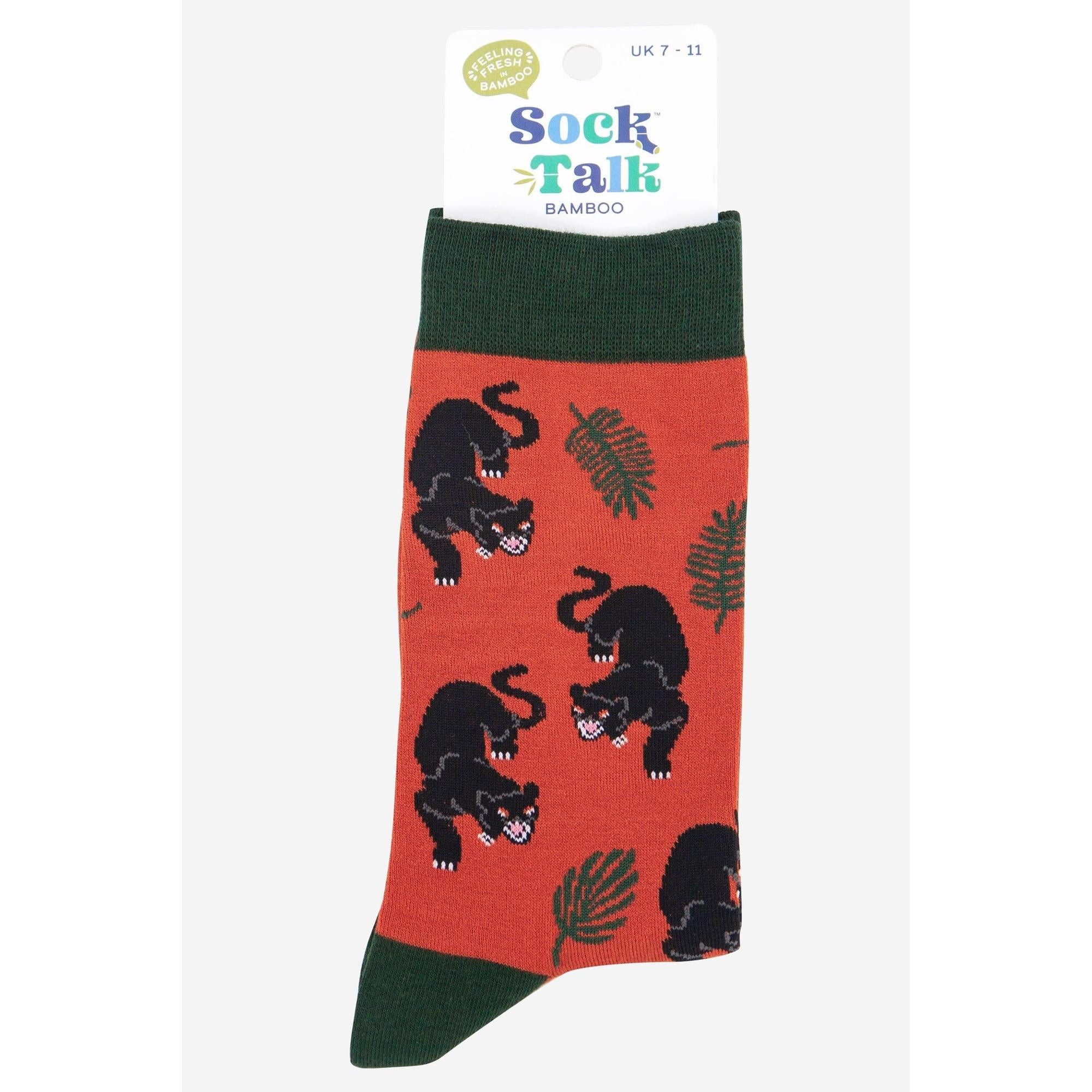 Sock Talk men's bamboo socks with black panther jungle leaf print, green toe and cuff, orange background.