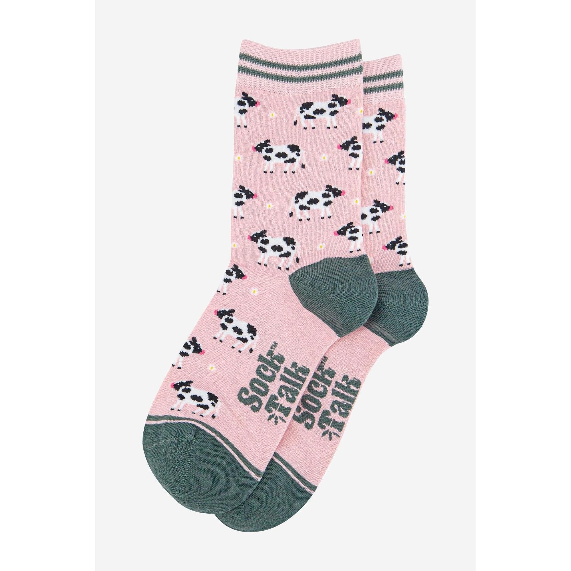 Sock Talk women's spring cow print bamboo socks with pink background, green heel and toe, and fun cow pattern.