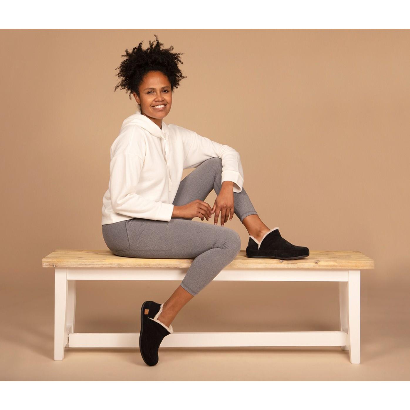 Strive Geneva women's black leather slip-on slippers with arch support, cozy shearling lining, and casual slip-on design.