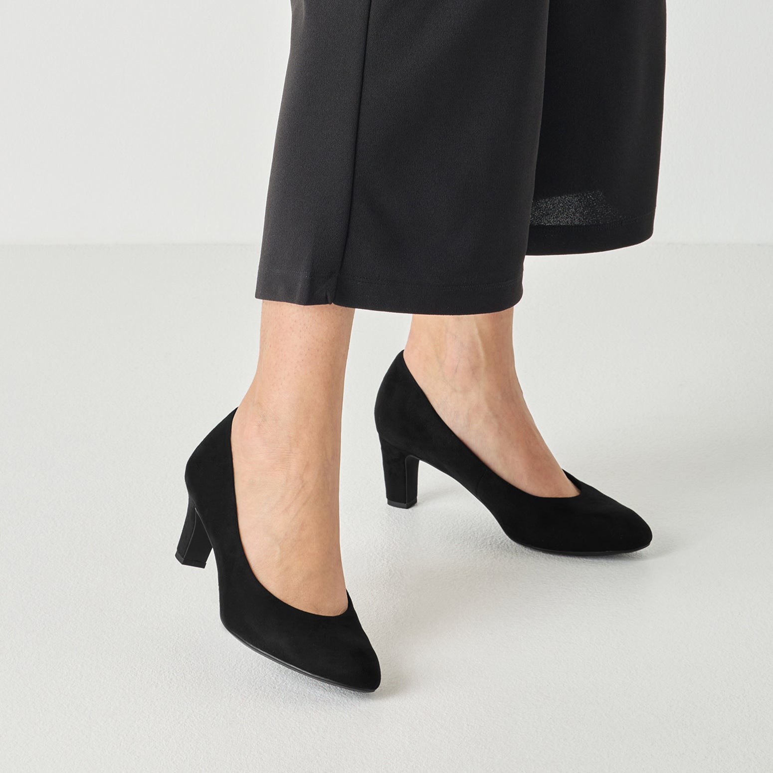 Black textile tamaris court shoe worn on foot, side view.
