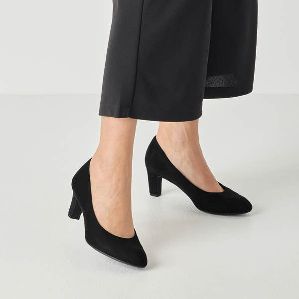 Black textile tamaris court shoe worn on foot, side view.