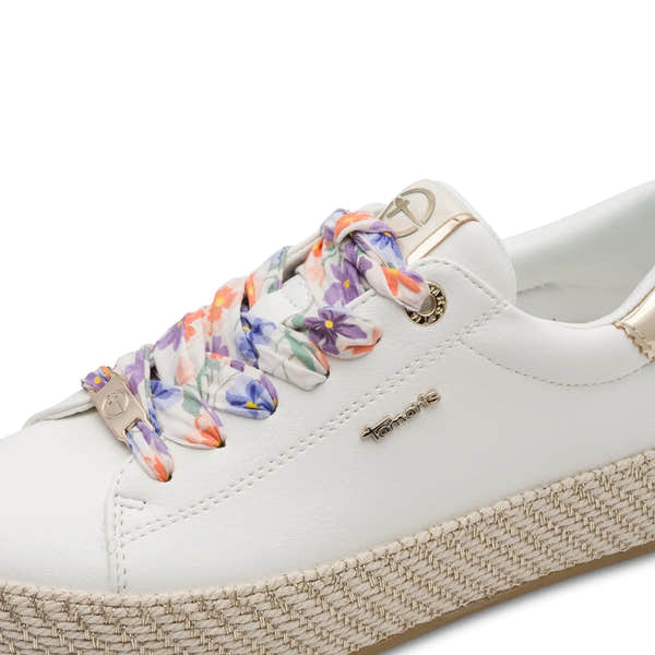 White lace-up sneaker with floral patterned laces, gold-tone accents, and a woven platform sole.
