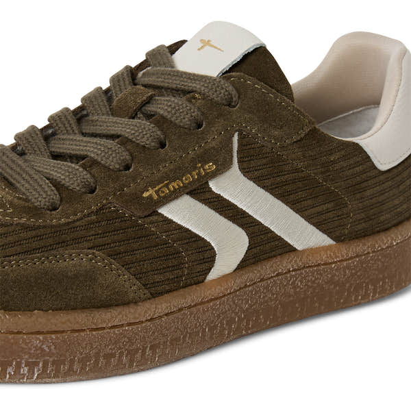 Close-up of the olive Tamaris lace-up trainer showing the mixed leather panels, stitching and trim.