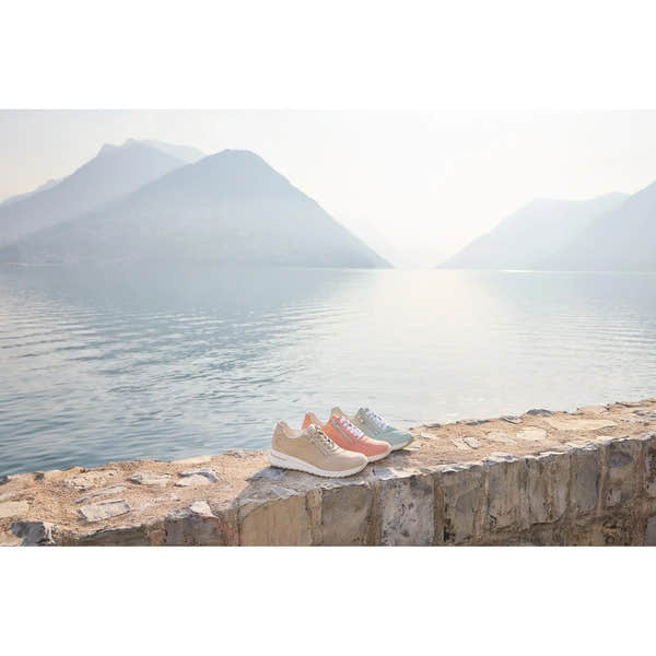 Waldlaufer H-Inessa women's wide beige leather trainer with arch support, zip and lace closure, on a stone ledge near a lake.
