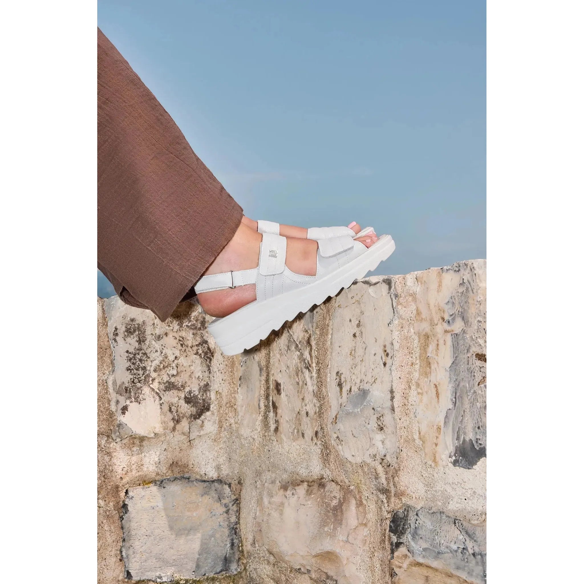 Waldlaufer 962001 189 148 H-Izzy women's wide off-white leather touch-fastening sandals on rocky surface with blue sky in background.