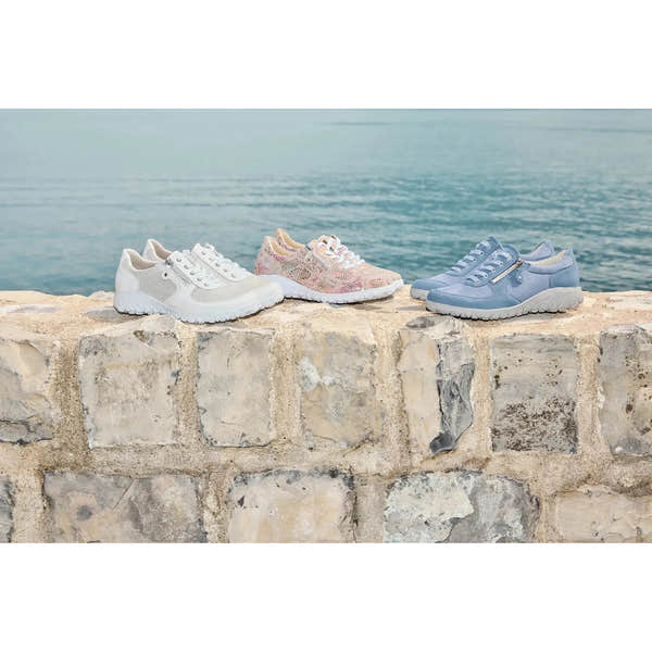 Waldlaufer H89001 Ladies wide fit denim nubuck sneakers with zip and lace fastening, soft cushioning, on a textured stone surface by the sea.