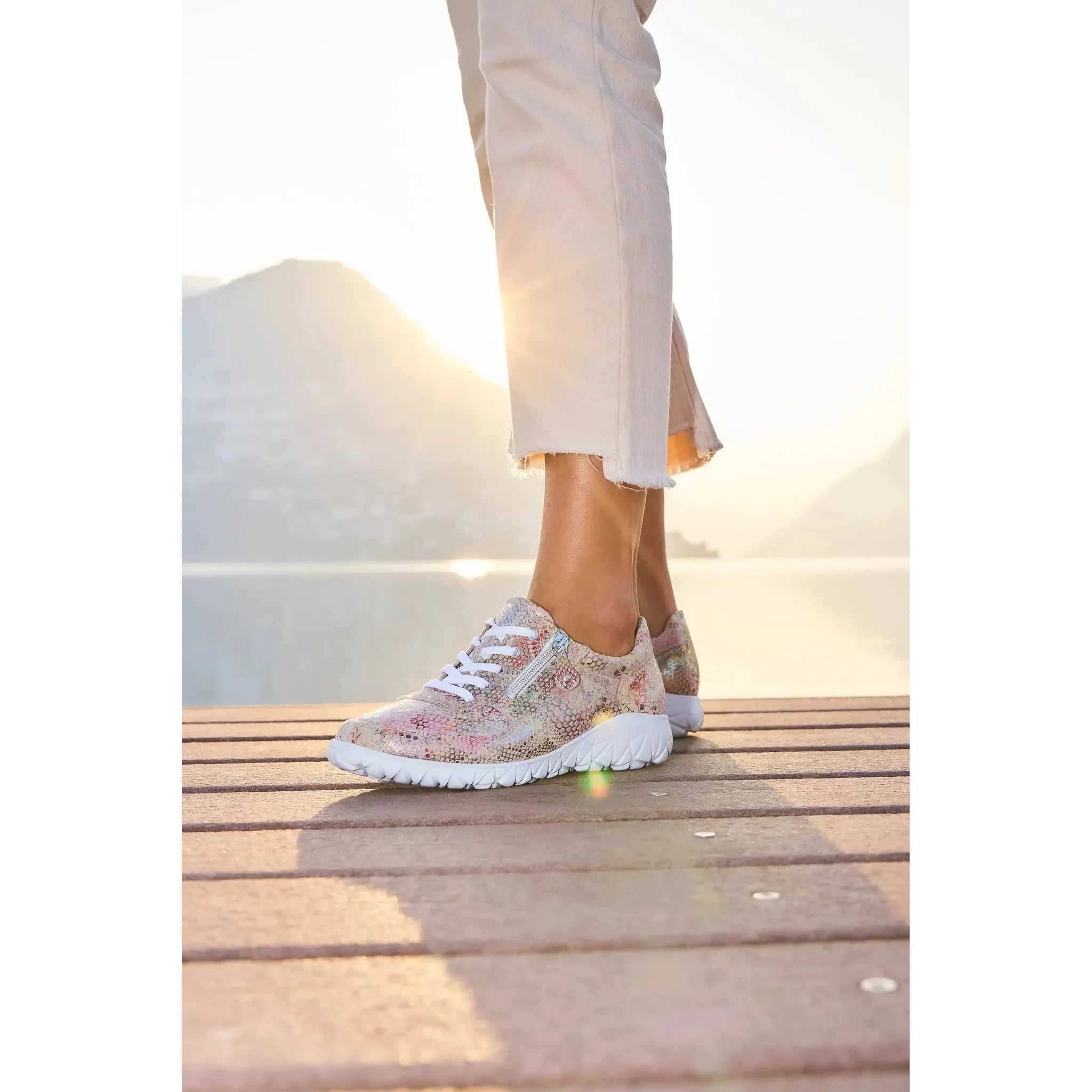 Waldlaufer H89001 ladies wide-fit multicolored nubuck trainers with zip and lace closures, worn by a person standing on a wooden dock at sunset.