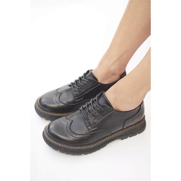 Women's black lace-up leather shoes with brogue details and chunky soles.