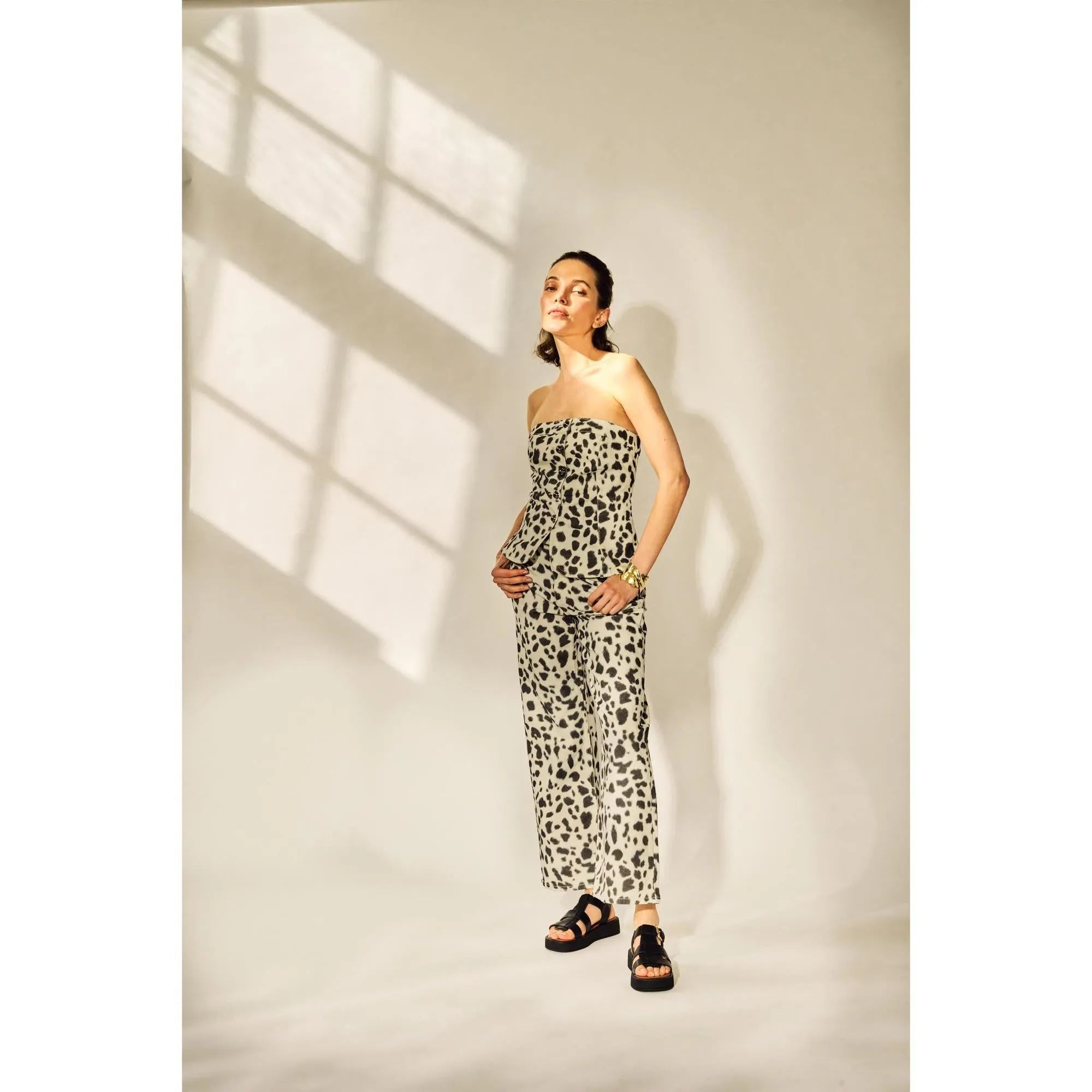 Black strapless sandals with touch fastening, chunky soles, and leather material, paired with a leopard print outfit.