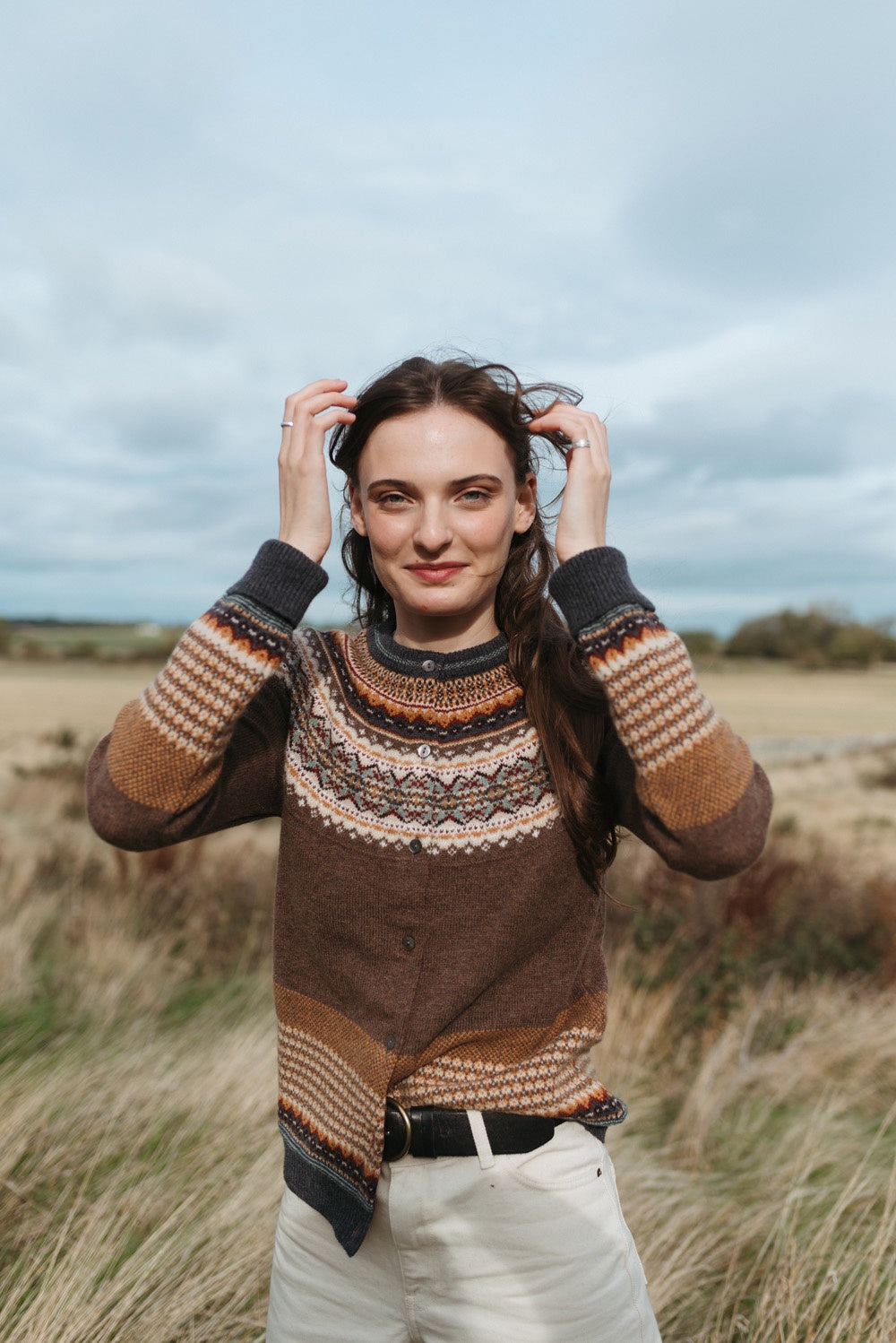 Eribé Alpine Cardigan in Hazel, model wearing the knit outdoors