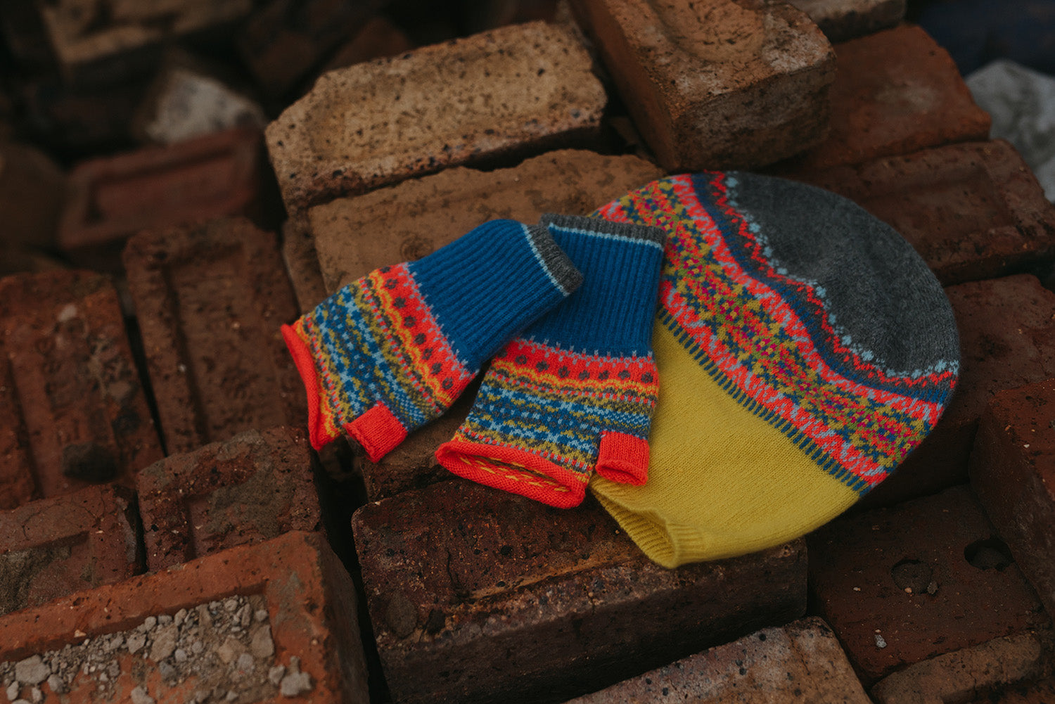 Eribé Alloa Beanie in Charm-Bonnie, hat styled beside matching fingerless mitts on stone, overhead view