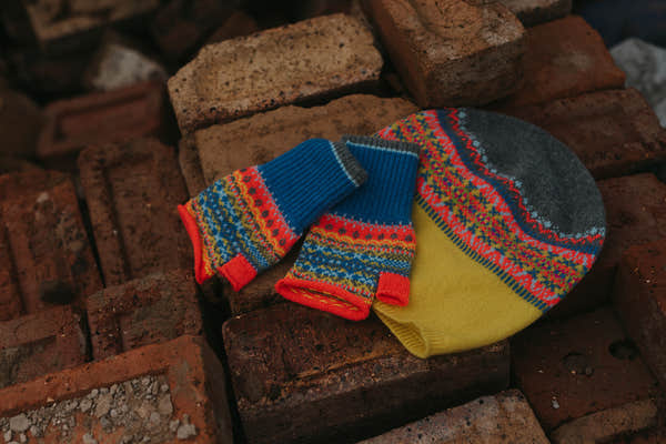 Eribé Alloa Beanie in Charm-Bonnie, hat styled beside matching fingerless mitts on stone, overhead view