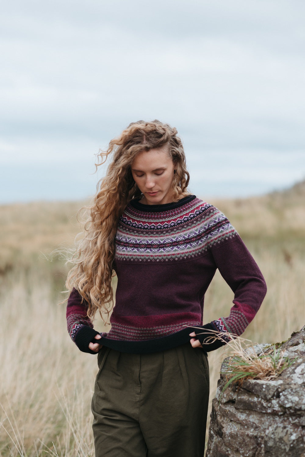 Eribé Alpine Sweater in Tyrian, model wearing the knit outdoors