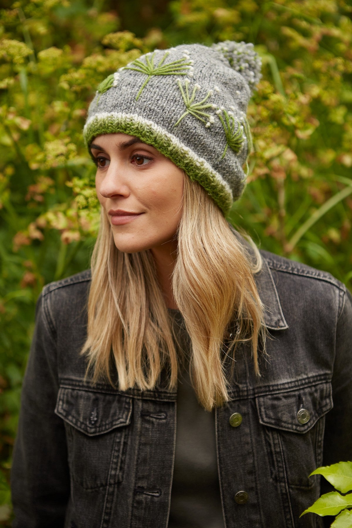 Pachamama Granchester Bobble Beanie, with green floral embroidery; product view.