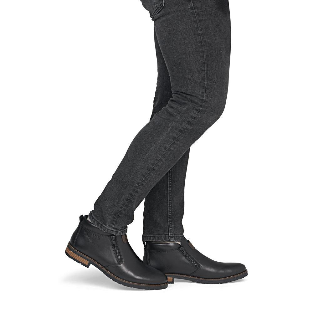 Rieker 14656-00 men's wide black leather water resistant side zip ankle boots, on-foot lifestyle view.