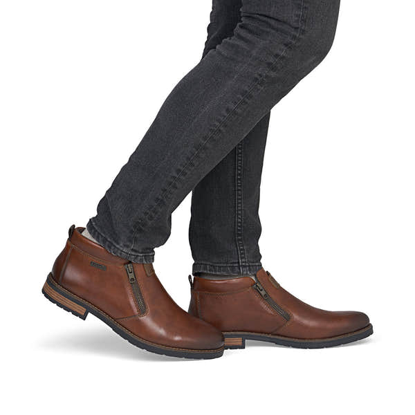 Rieker 14656-24 men's wide brown leather water resistant side zip ankle boots, on-foot lifestyle view.