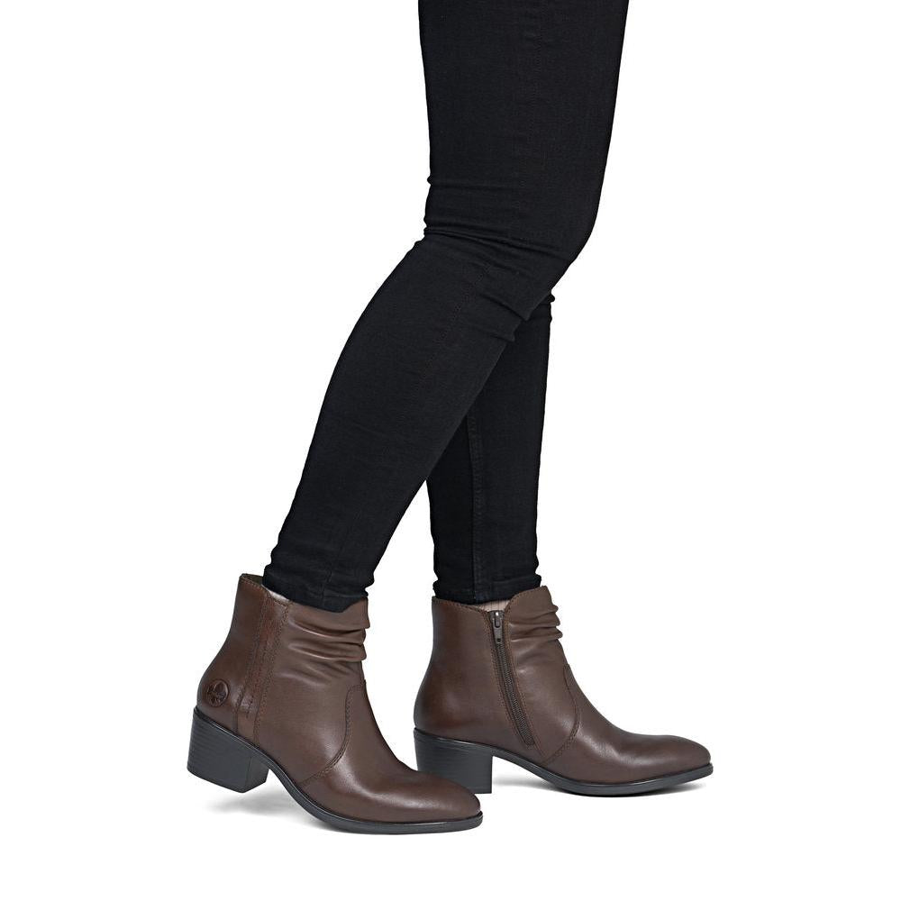 Rieker 73953-27 women's brown leather side zip ankle boots, on-foot lifestyle view.