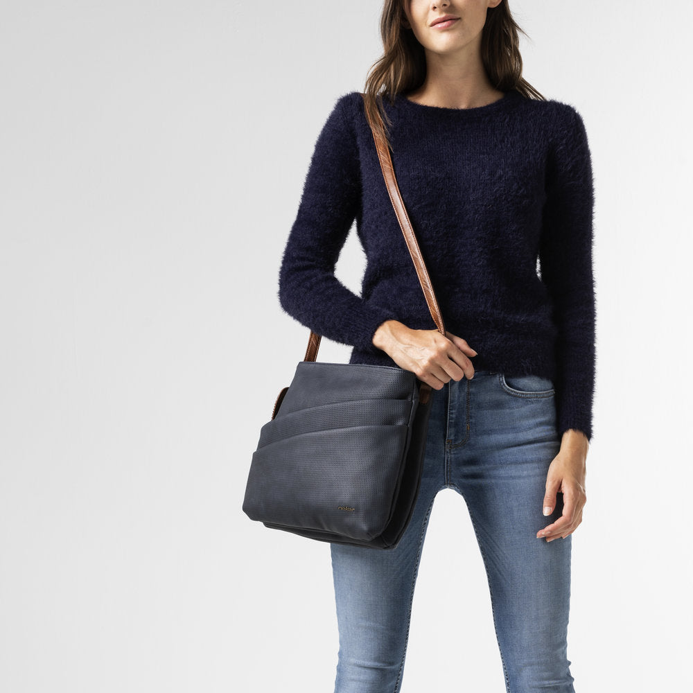 Rieker H1005-14 women's navy handbag with cross over tan strap, lifestyle view 2 of 2.