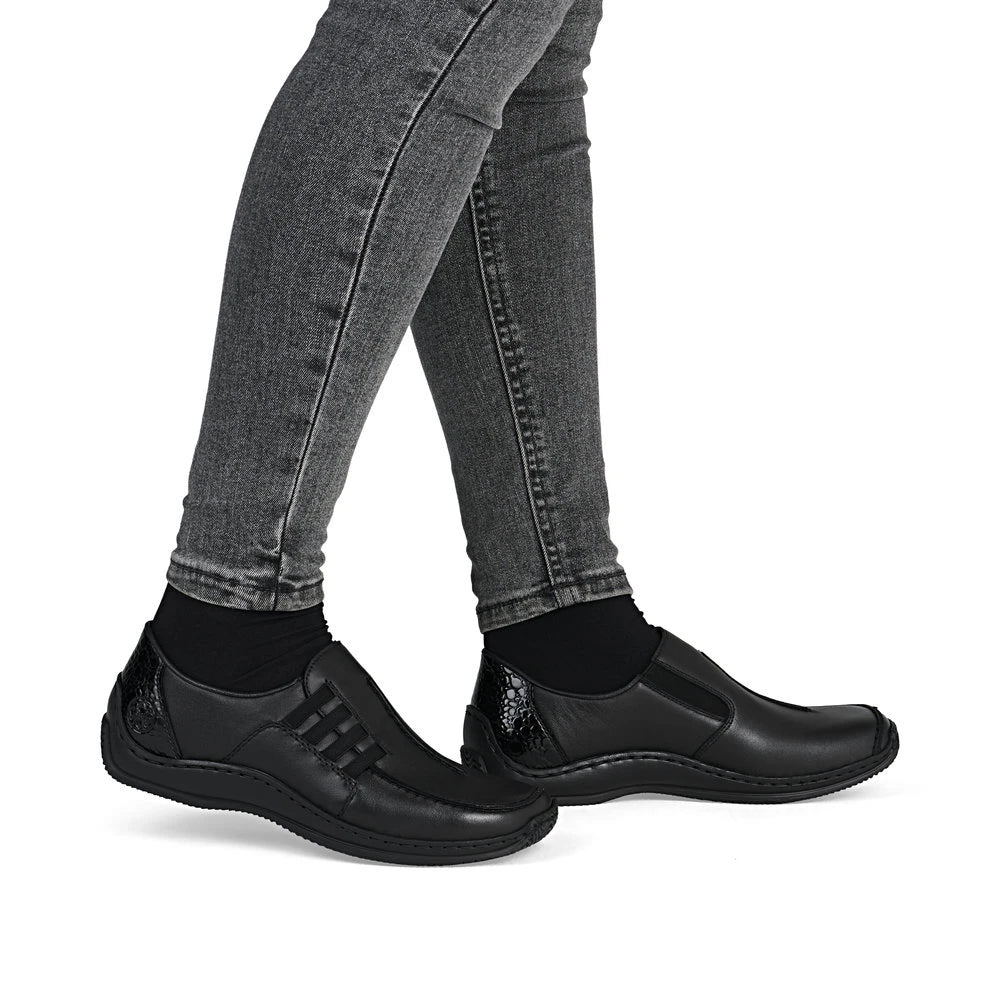 Rieker L1777-00 women's black leather slip on shoes, on-foot lifestyle view.