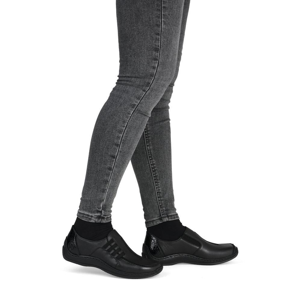 Rieker L1777-00 women's black leather slip on shoes, on-foot lifestyle view.
