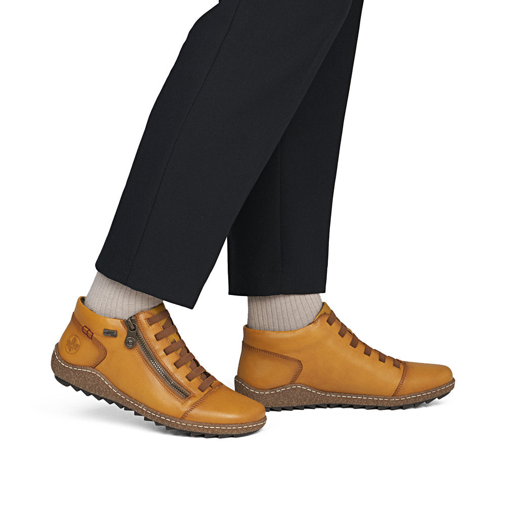 Rieker L7563-68 women's narrow brown leather water resistant side zip shoes, on-foot lifestyle view.