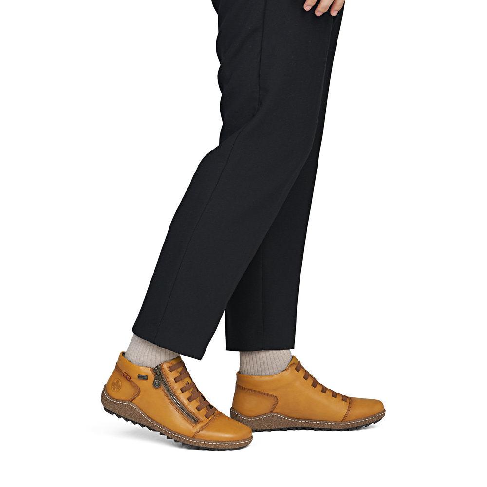 Rieker L7563-68 women's narrow brown leather water resistant side zip shoes, on-foot lifestyle view.