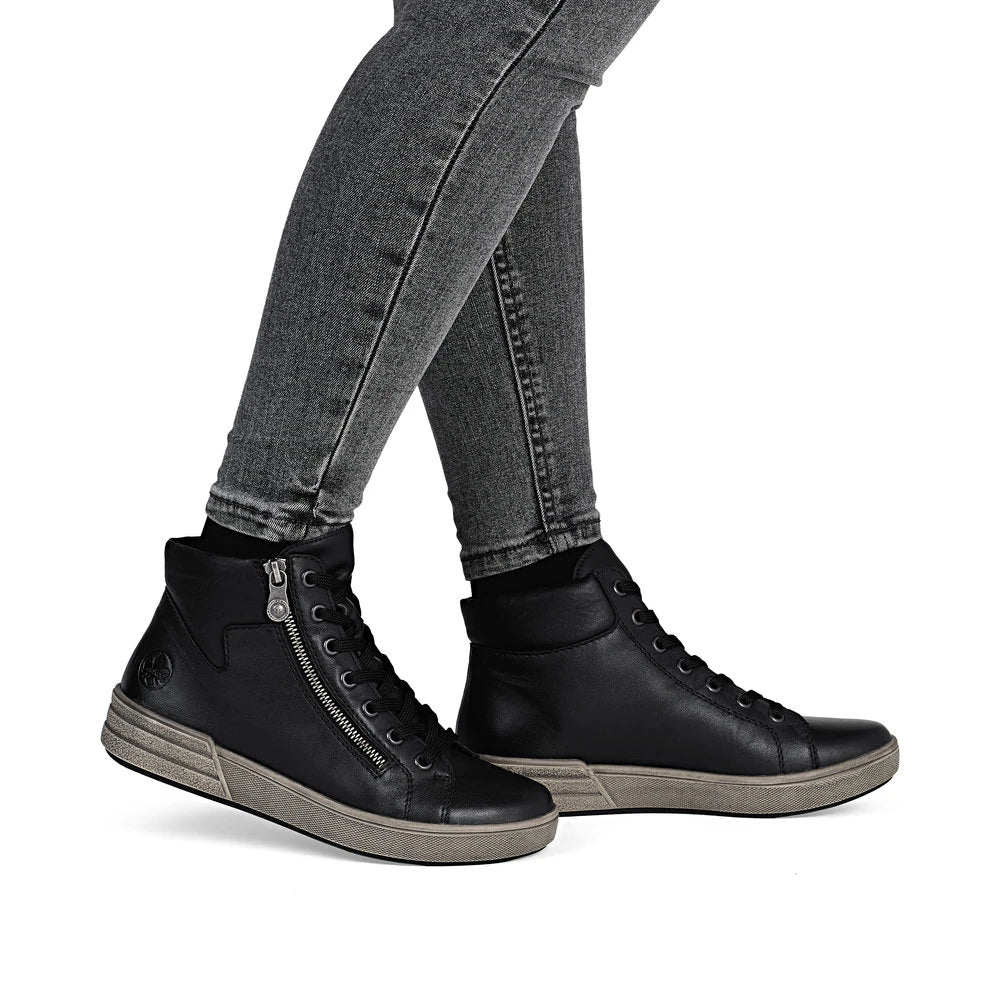 Rieker X0709-01 women's black leather zip & lace ankle boots, on-foot lifestyle view.