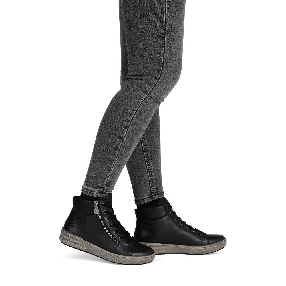 Rieker X0709-01 women's black leather zip & lace ankle boots, on-foot lifestyle view.