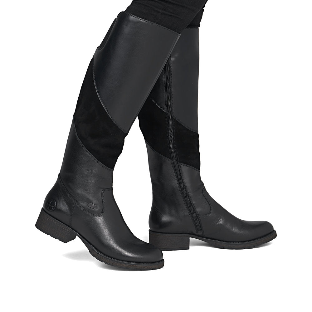 Rieker Z9566-00 women's black leather water resistant side zip knee high boots, on-foot lifestyle view.