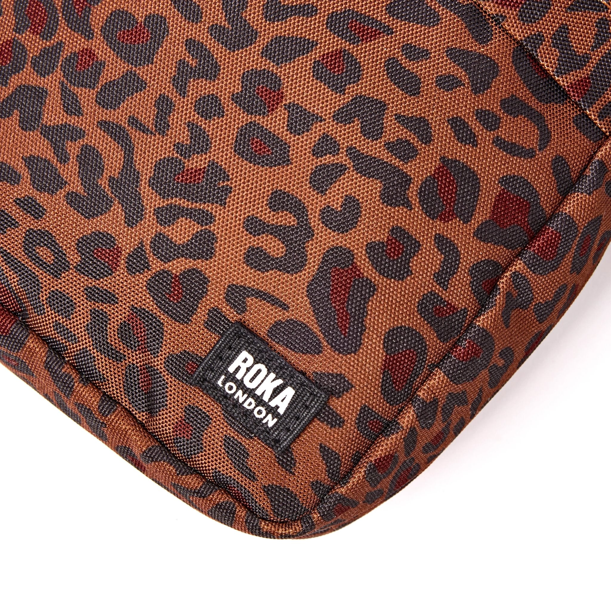 Roka Bond Mini Leopard Recycled Canvas Crossbody Bag, brand label detail.