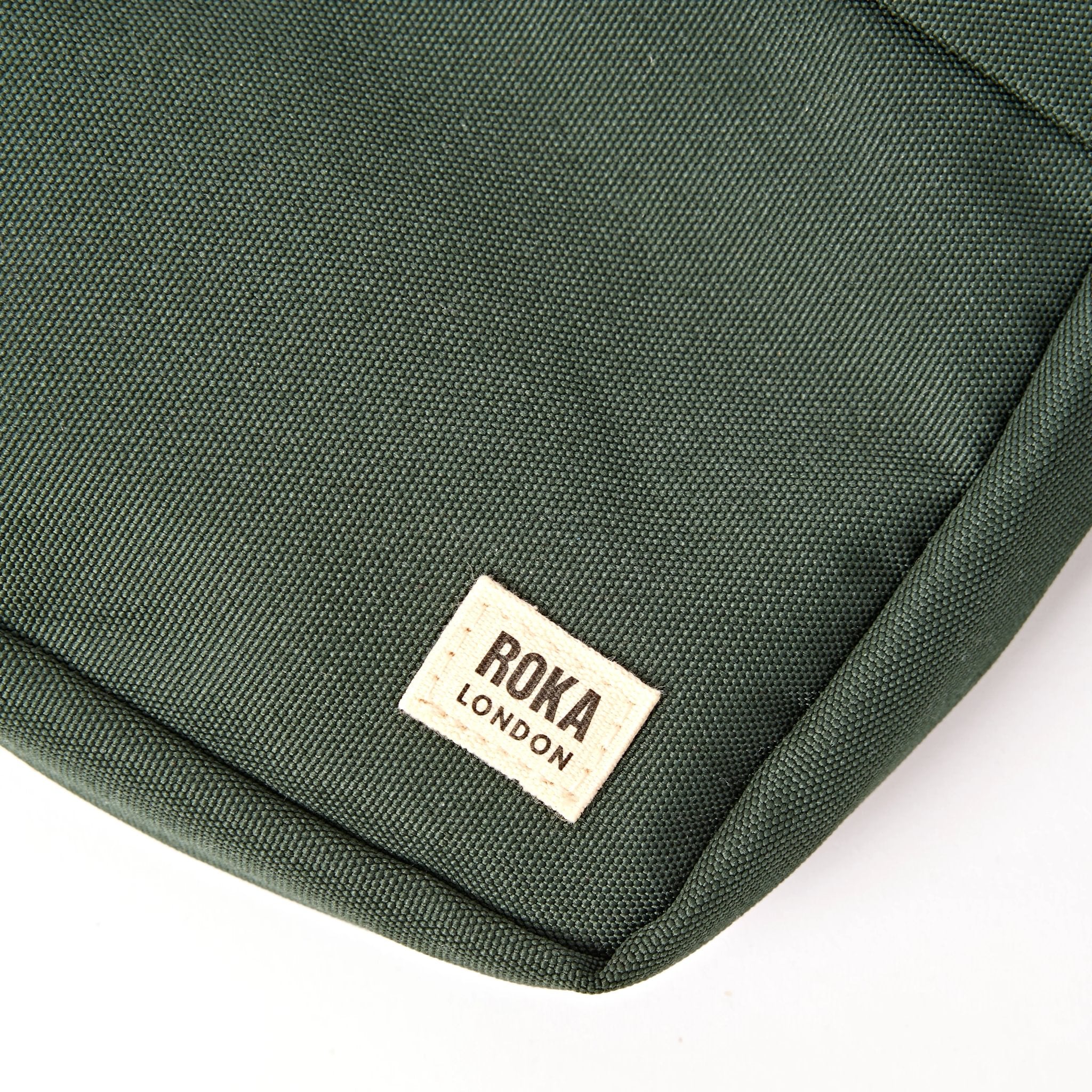 Roka Bond Thunderstorm Recycled Canvas Crossbody Bag, brand label detail.