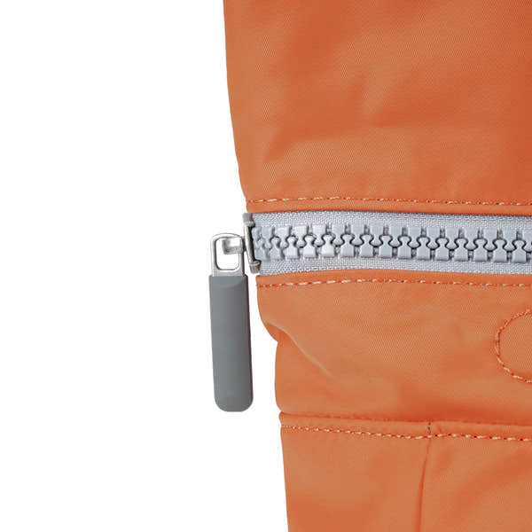 Roka Canfield Medium Burnt Orange Recycled Nylon Backpack, zip detail.
