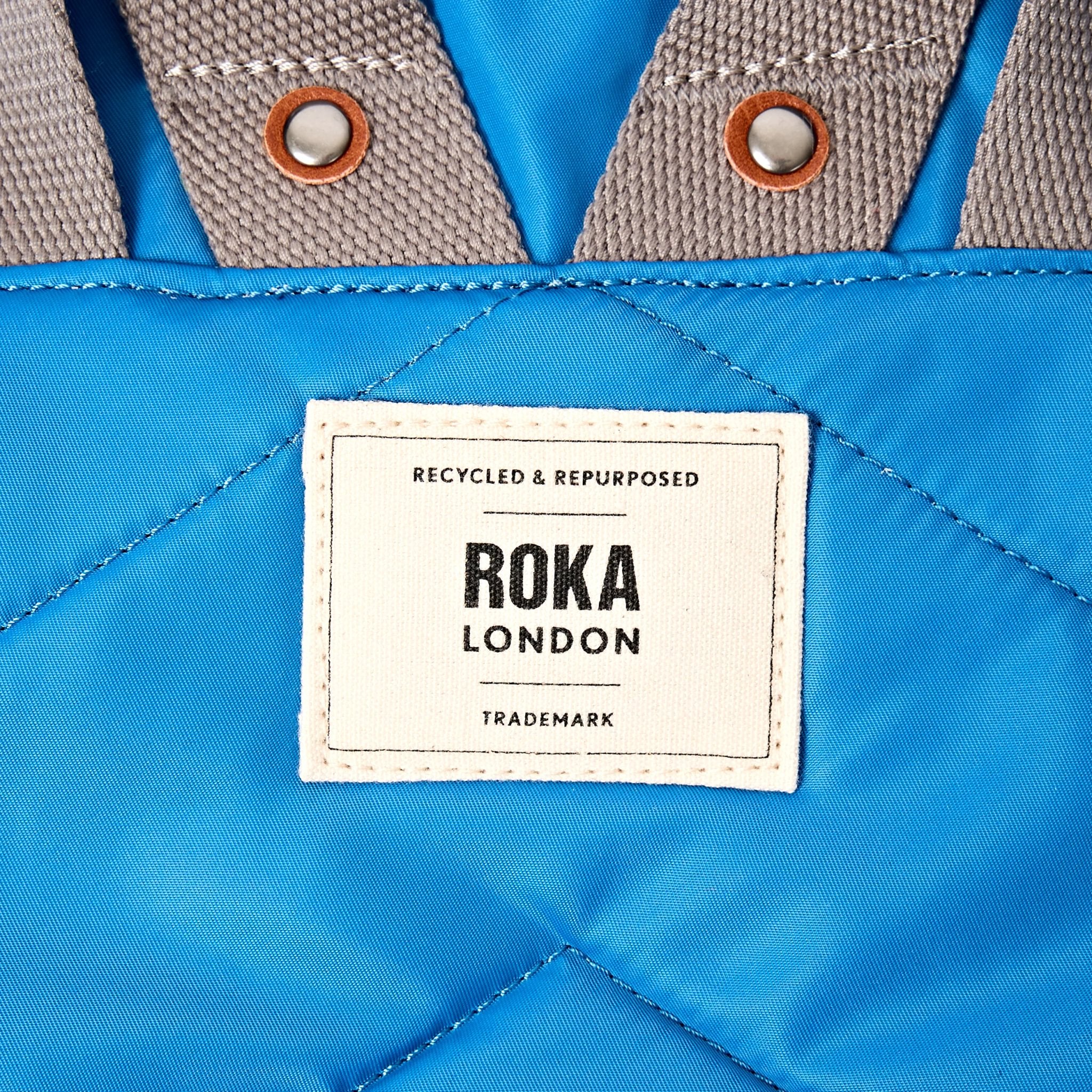 Roka Canfield Medium Malibu Blue Recycled Nylon Backpack, brand label detail.