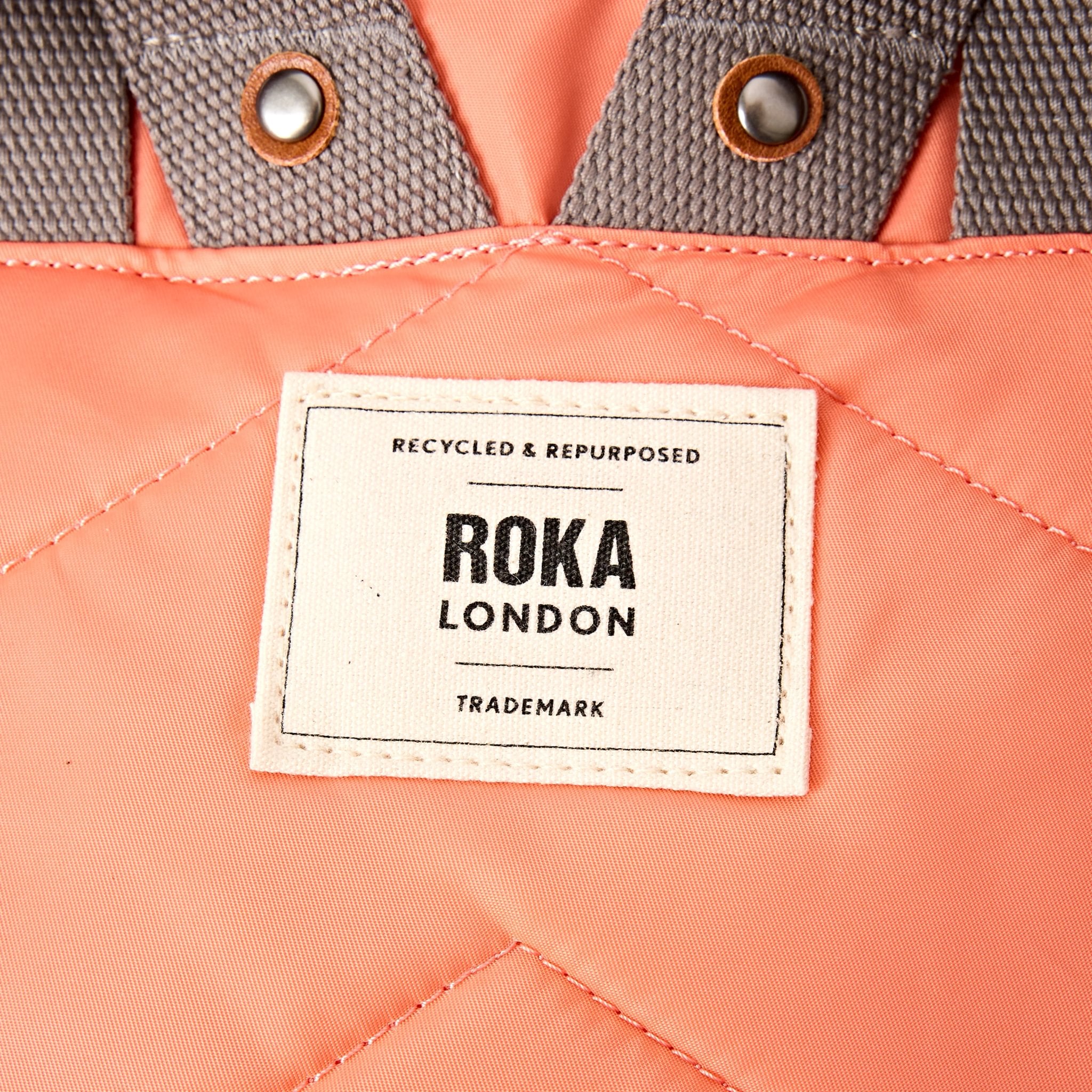 Roka Canfield Medium Sugar Coral Recycled Nylon Backpack, brand label detail.